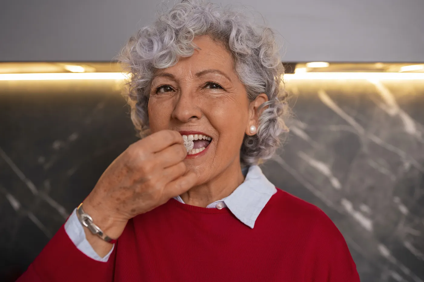 Paciente sorrindo e mastigando com prótese protocolo instalada
